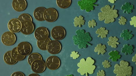 overhead studio shot of gold coins with shamrock symbol with shamrock shapes on background to celebrate st patricks day