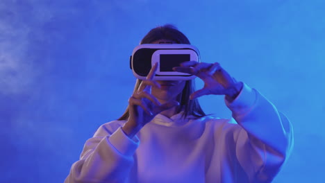 giovane donna che utilizza un auricolare vr su uno sfondo colorato di luci al neon 1