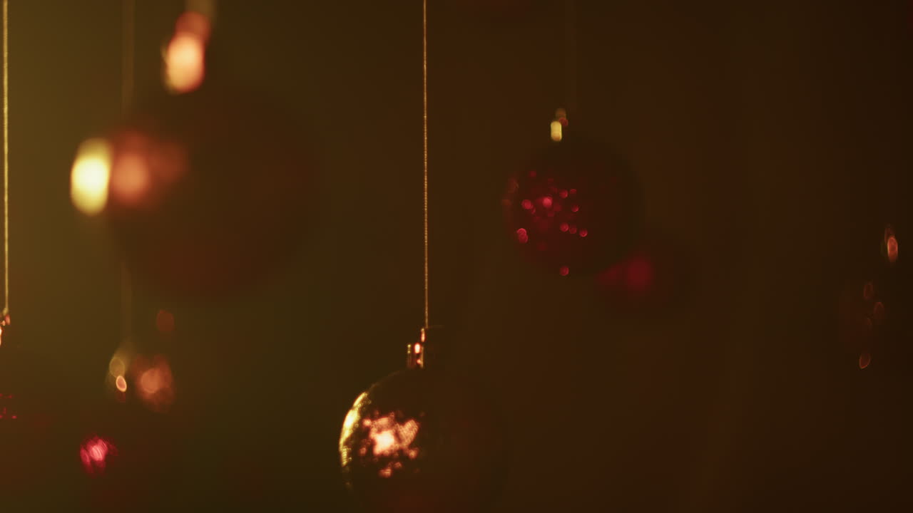 Slow motion Christmas balls hanging from the ceiling with abstract black