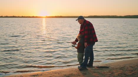 Wunderschöner-Sonnenuntergang-Am-Fluss.-Alter-Fischer-Und-Kleiner-Junge-Fangen-Fische.-Opa-Und-Kind-Verbringen-Das-Wochenende