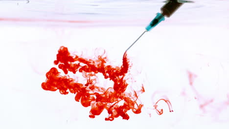 needle injecting blood into water