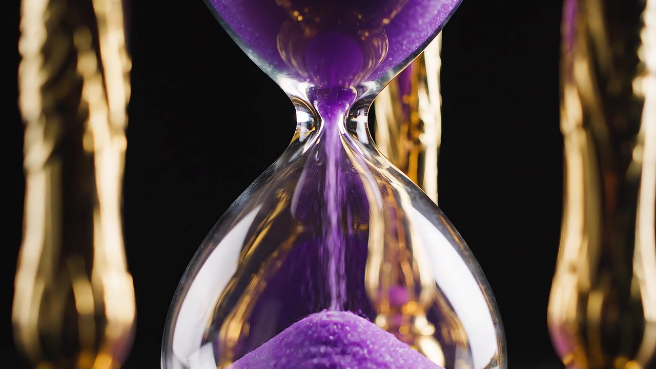 Elegant Golden Hourglass with Purple Sand on Black Background