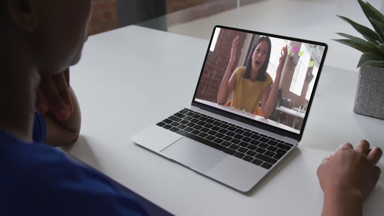 African american woman talking on video call on laptop with female office colleague at home