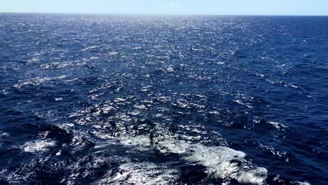 Ocean-waves-as-the-sun-reflects-on-the-frothy-rolling-waters-in-slow-motion