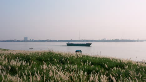 Imágenes-Aéreas-De-Drones-Sobrevolando-La-Costa-Del-Mekong-Avanzando-Rápidamente-Hacia-Un-Barco-De-Transporte