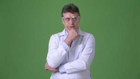 mature handsome man doctor against green background