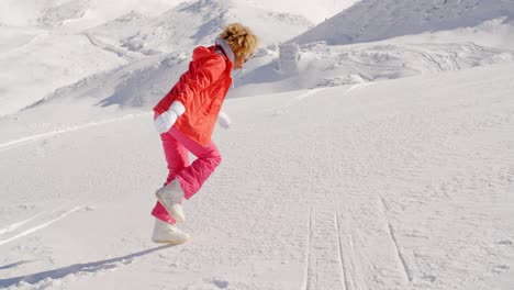 persona en traje de nieve corriendo por la montaña