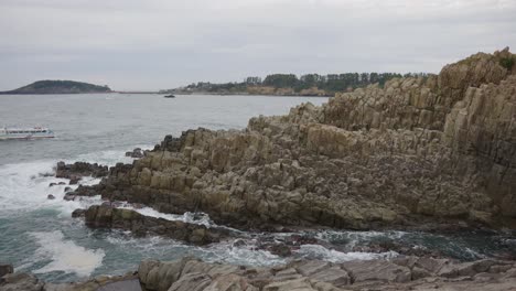 Tojinbo-Cliffs-and-Tour-Boat-in-Slow-Motion,-Fukui-Prefecture-Japan