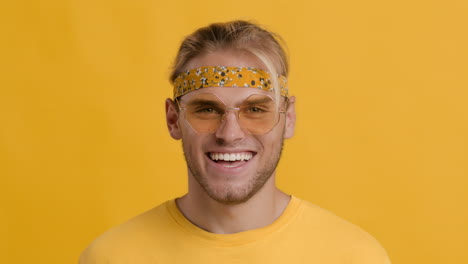 man wearing a yellow bandana, glasses, and yellow shirt