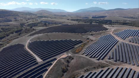 drone over new renewable energy photovoltaic solar power park farm clear sky mountains