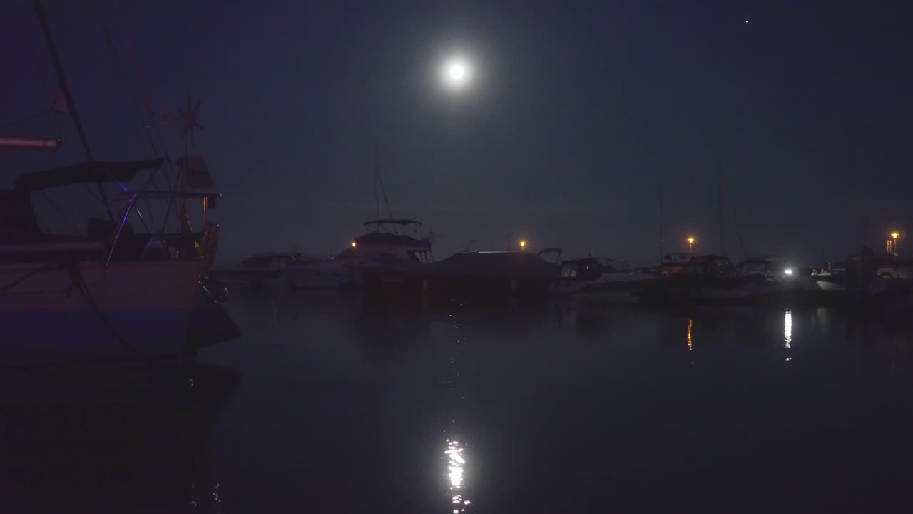 Still shot of a boats floating calmly in a moonlight