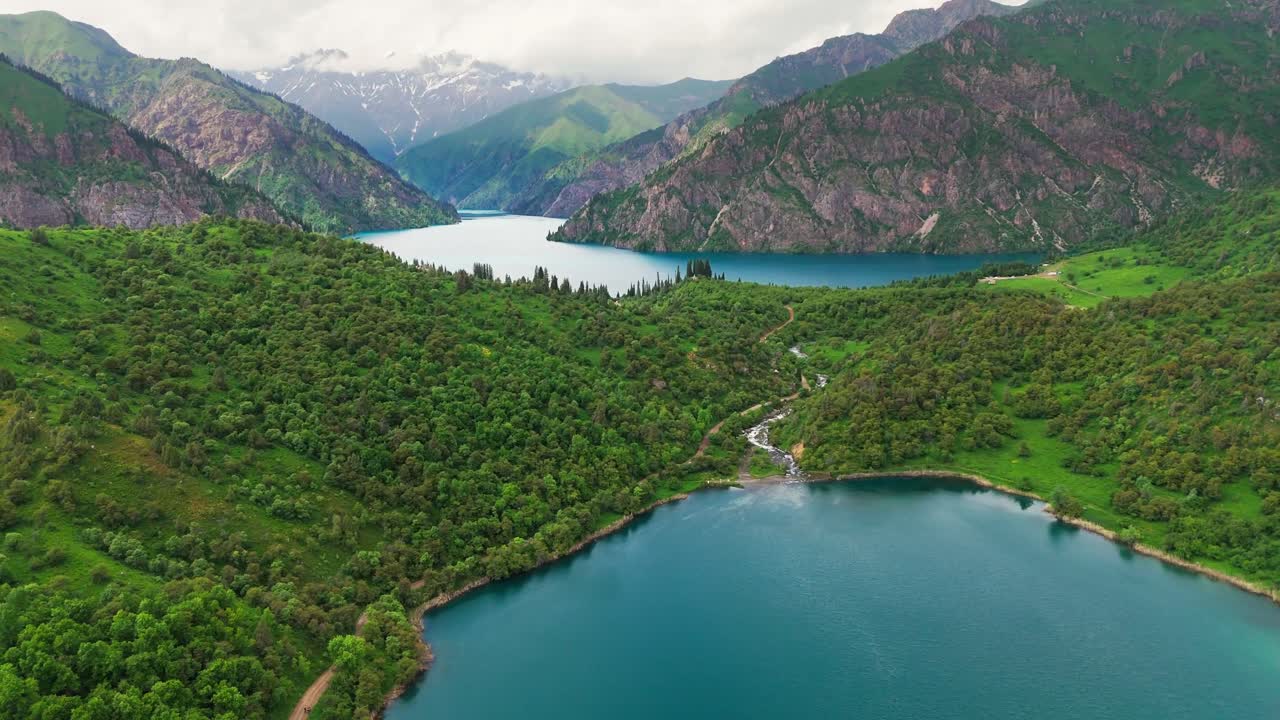 aerial footage of Sary-Chelek Lake, Kyrgyzstan. Surrounded by lush green forests and dramatic peaks, this UNESCO Biosphere Reserve is a pristine natural wonder in Central Asia