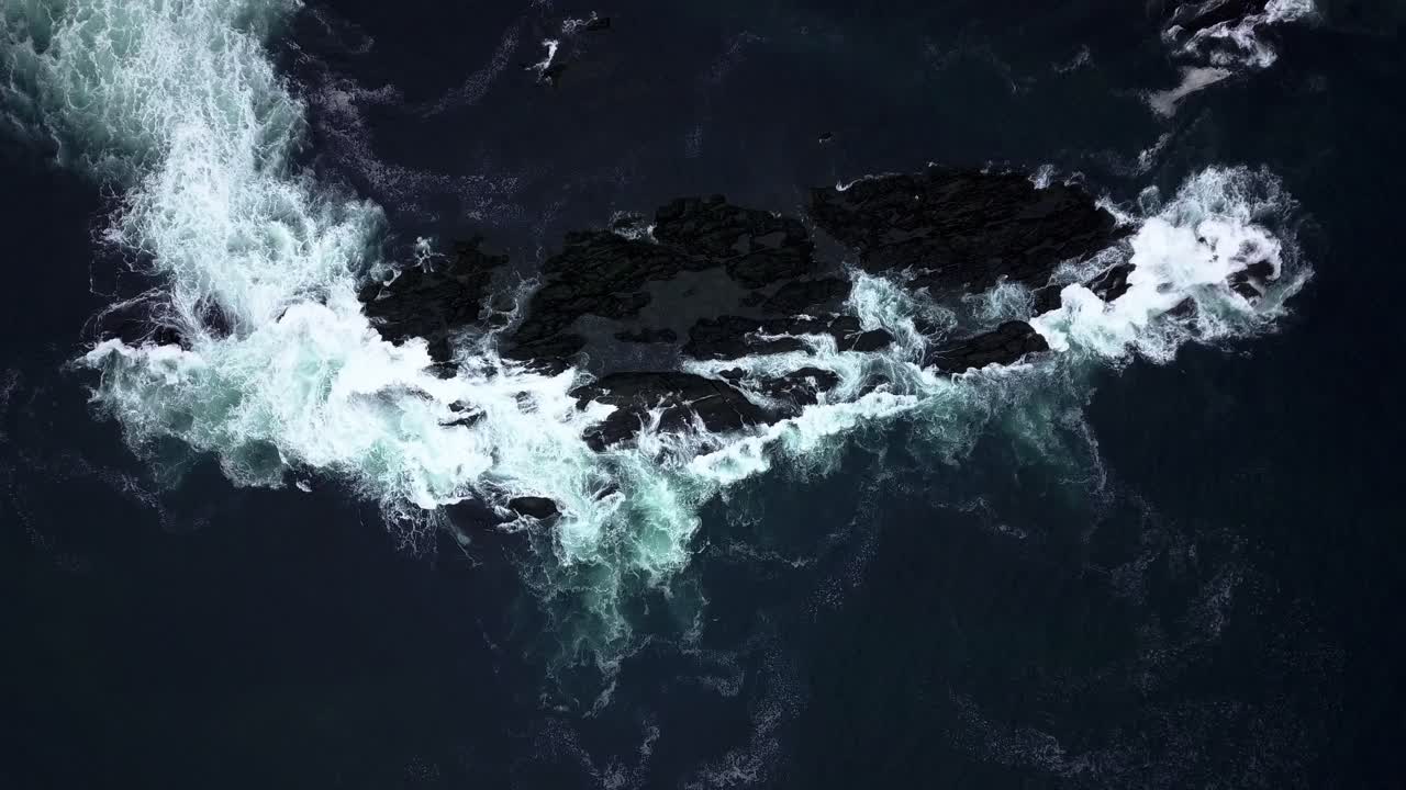 Waves crashing on shallow rocks, from a distance