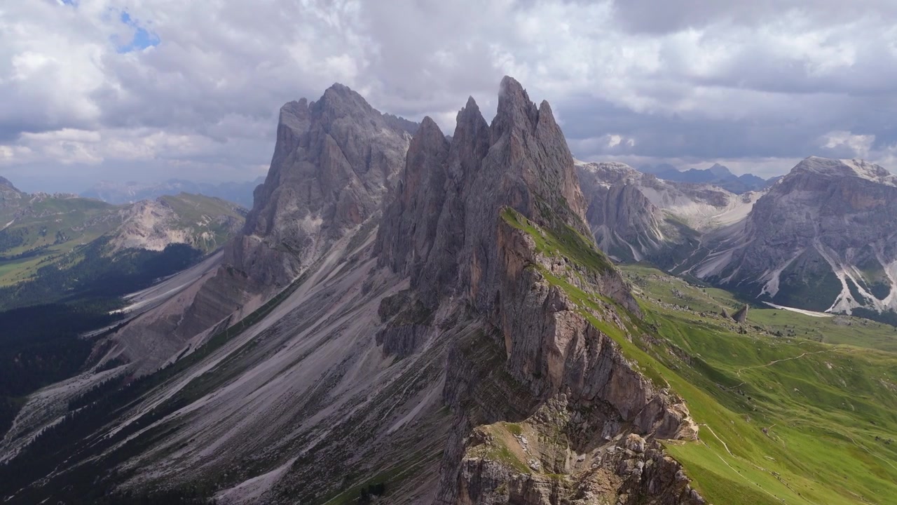 Smooth cinematic orbit around the jagged limestone peaks of Seceda revealing the dramatic alpine landscape of the Dolomites.