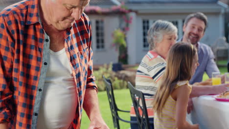 family having a barbecue together in garden