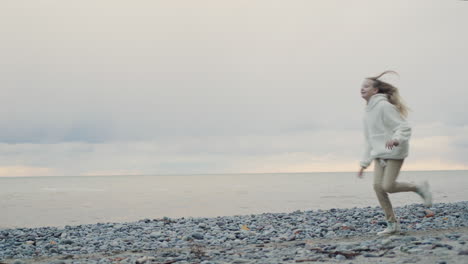 a teenage girl runs along the shore of a picturesque lake. slow motion video