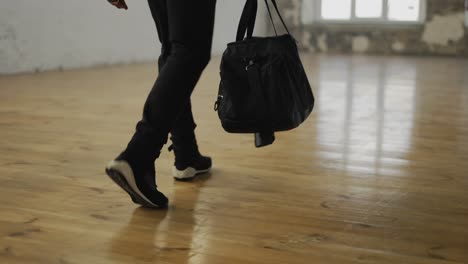 Cropped-View-Of-An-Athlete-Walking-Into-Room-With-A-Bag,-Ready-To-Start-Training