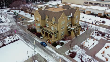 Aerial-closeup-of-Governemnt-House-decorated-with-Christmas-festive-wreaths-garlands-drone-fly-out-pan-at-the-grounds-of-the-old-Royal-Museum-on-a-winter-afternoon-with-hardly-any-cars-in-parking-area