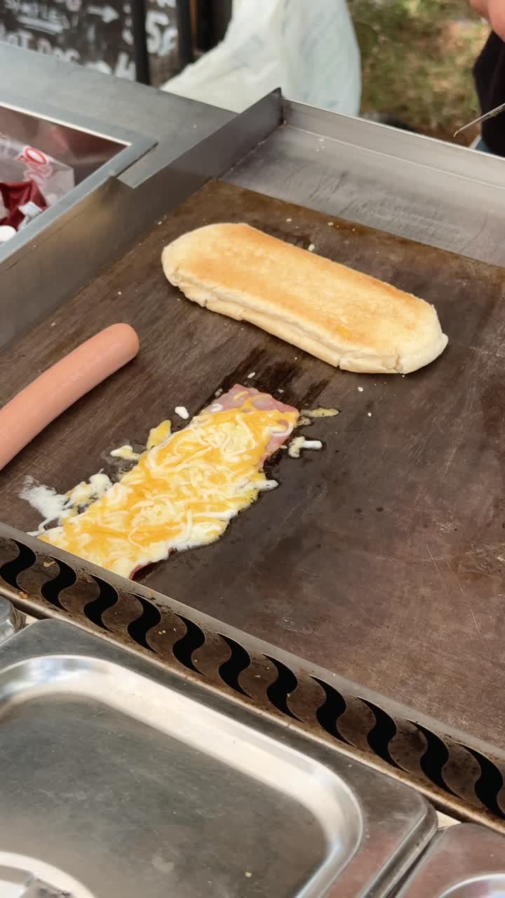 Hot dog and sandwich being cooked on griddle