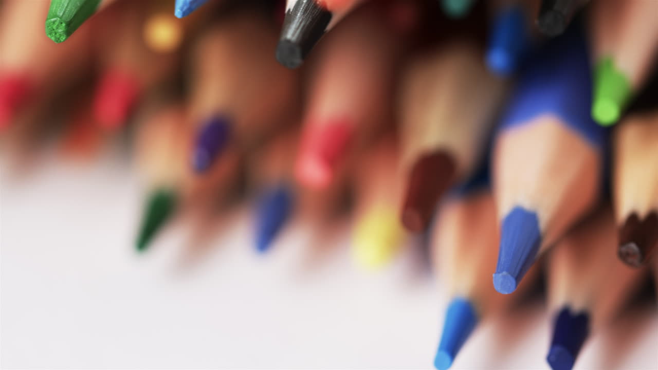primer plano de lápices de colores sobre un fondo blanco, en cámara lenta