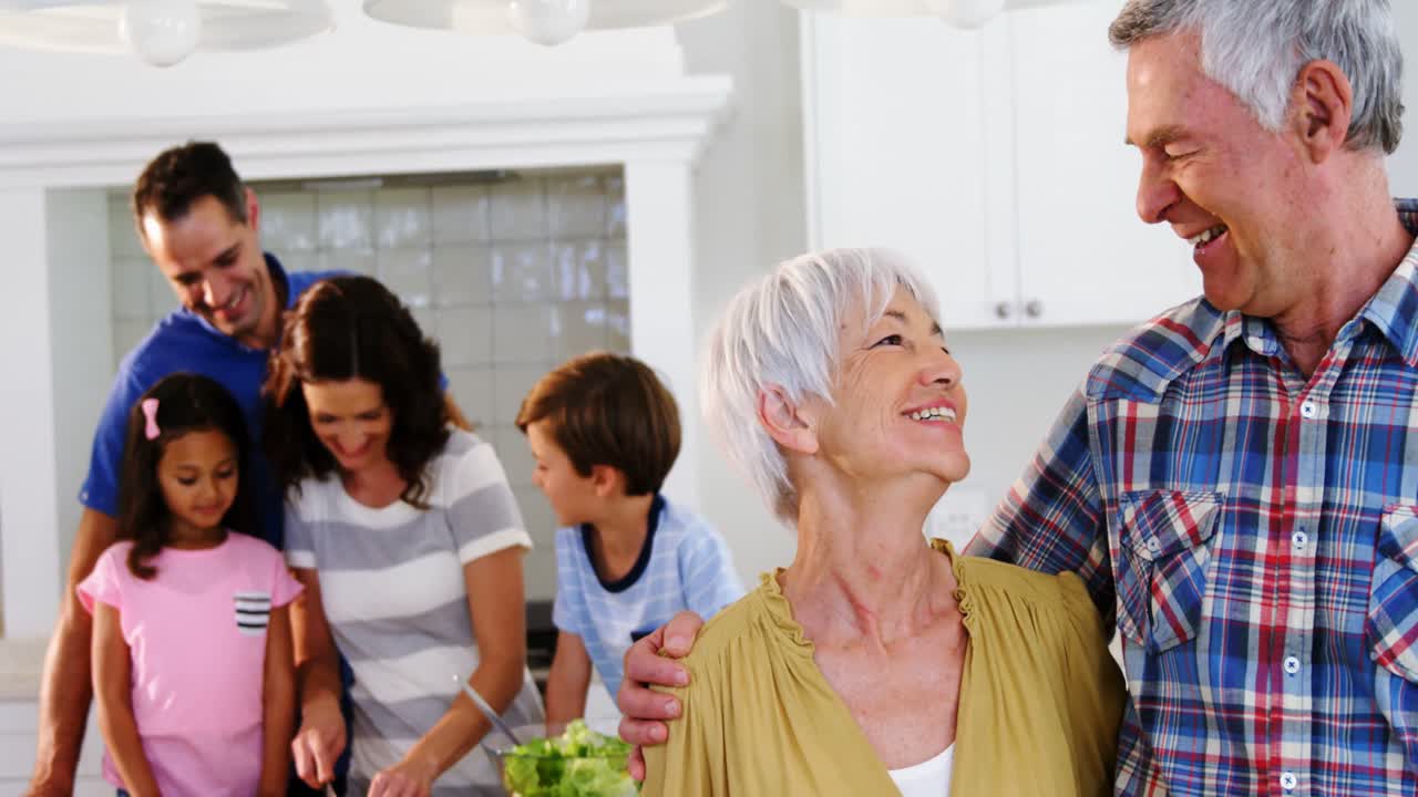 Portrait of senior couple standing with arm around in kitchen