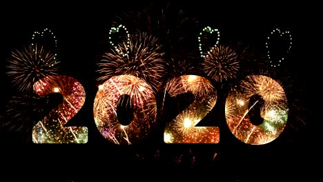 4k. firework of year 2020 greeting during new year eve countdown celebration, loop of real golden and heart shape fireworks festival in the sky display at night with colorful