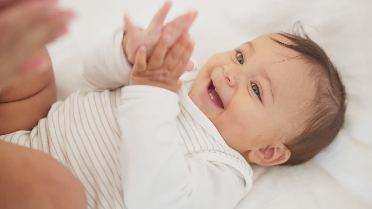 Premium stock video - Infant baby, clapping hands and bed with parent