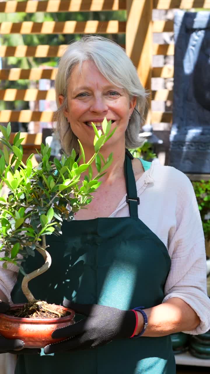 Woman Holding a Bonsai Tree