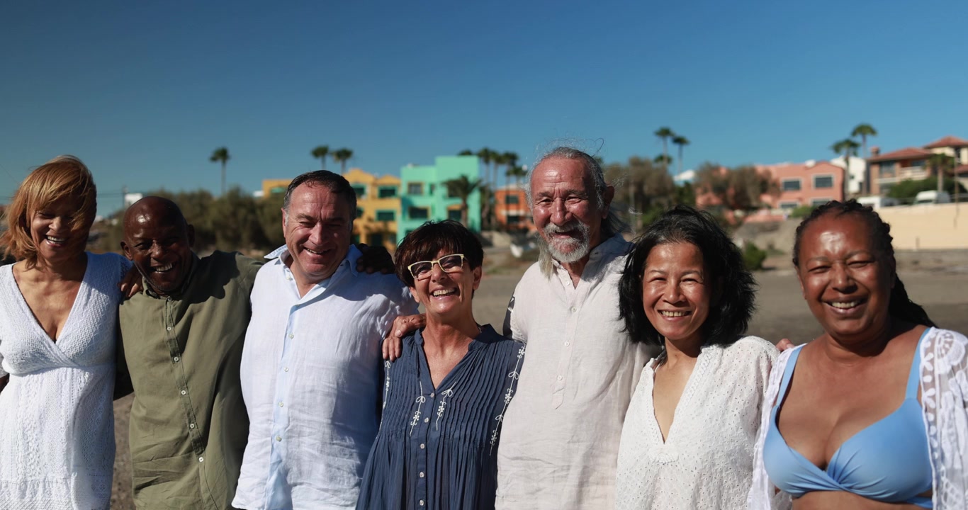 Happy Diverse Senior Friends Smiling and Laughing on a Sunny Beach