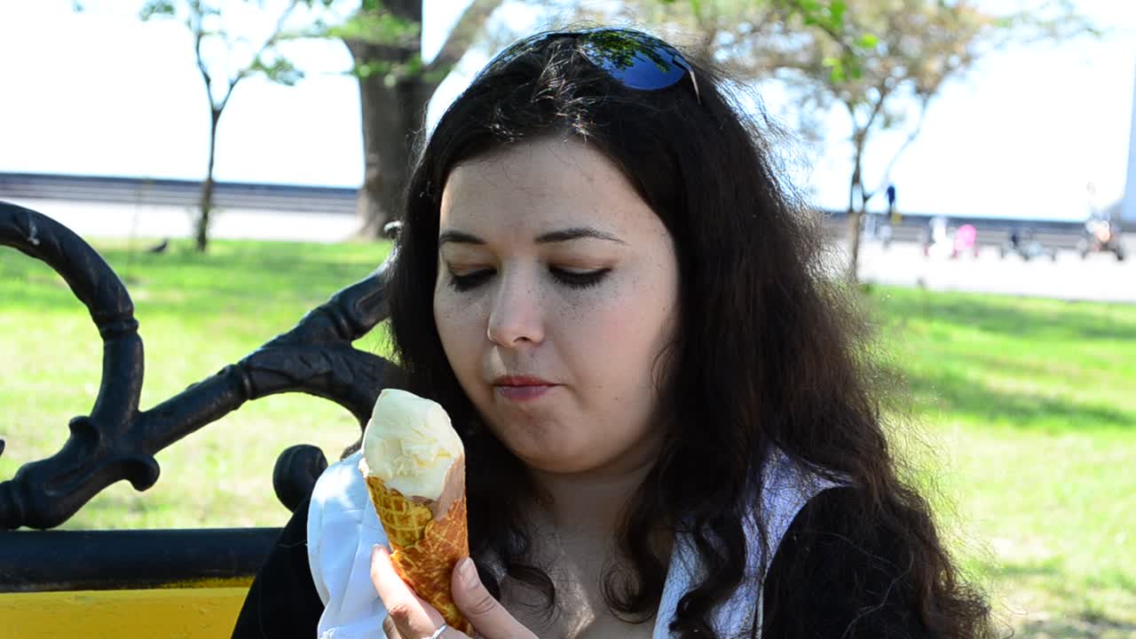 A menina come sorvete. A linda menina com sorvete na mão