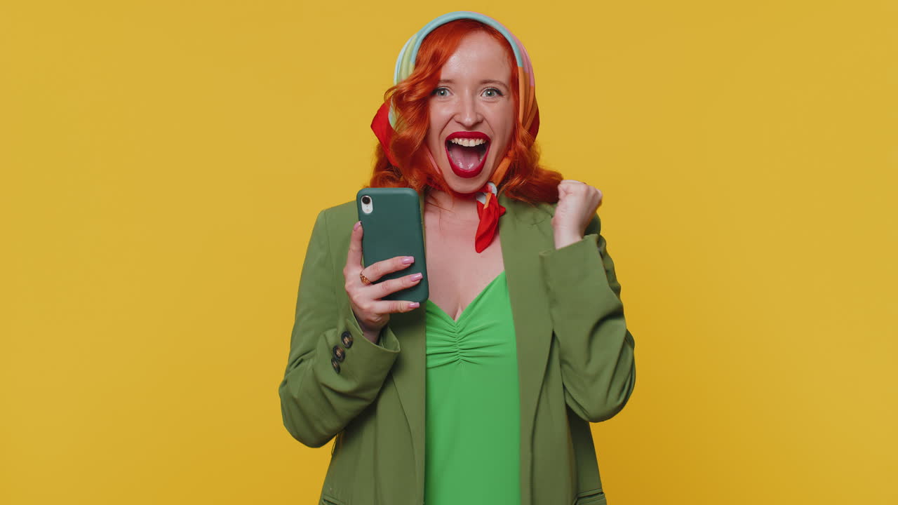 mujer feliz y emocionada usa el teléfono móvil y dice wow, sí, descubrí una gran noticia sobre una gran victoria haciendo un gesto de ganador