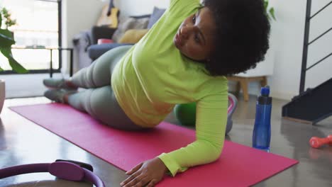 african american female plus size lying on exercise mat working out