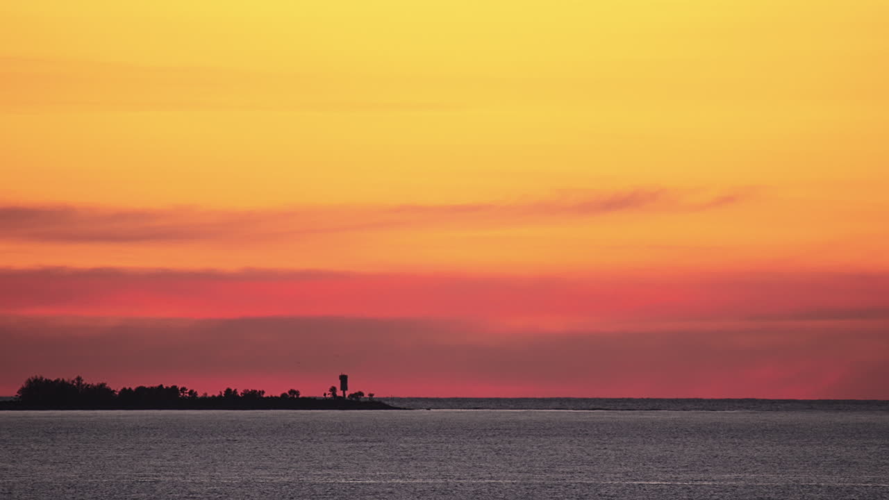 Stunning Sunset over Ocean with Silhouette of Lighthouse on Island