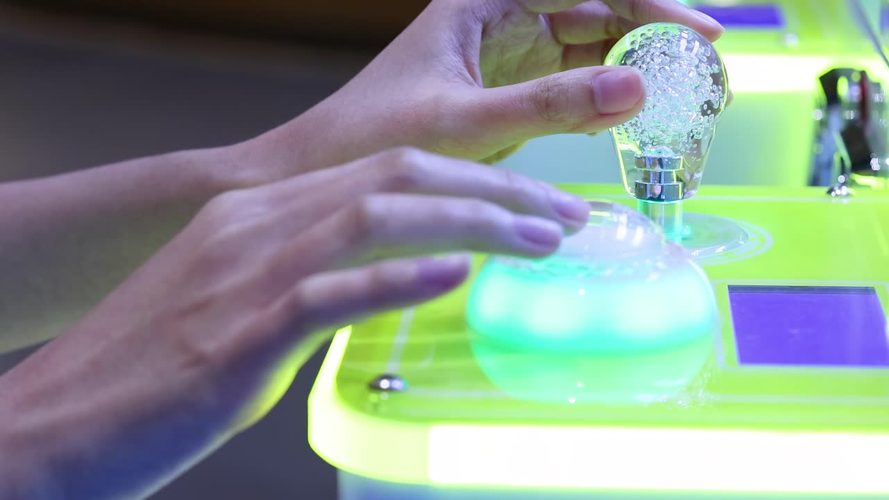 manos interactuando con un armario de juegos brillantes