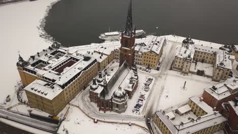 zoom out cinematic aerial view of historic riddarholmen church located in old town of stockholm, sweden