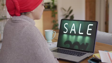 Mujer-Birracial-Usando-Laptop,-Compras-En-Línea-Durante-La-Venta,-Cámara-Lenta