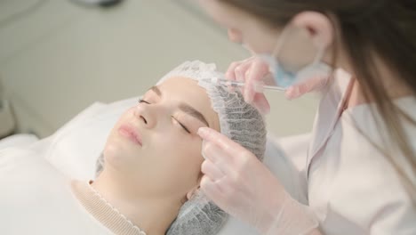 woman undergoing facial treatment at cosmetologist clinic