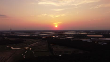 amazing drone shot of the sunset with nature and some buildings