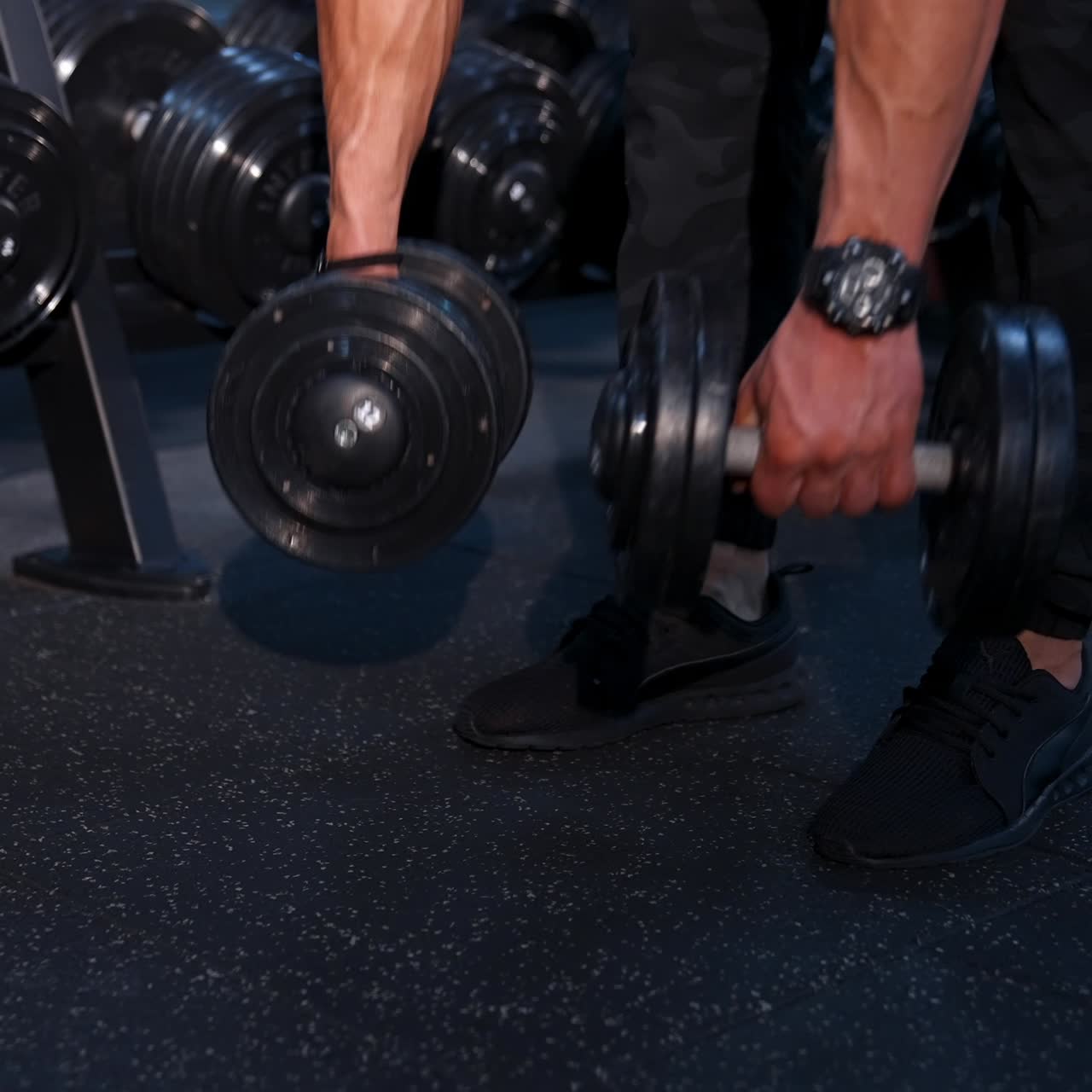 Bodybuilder exercising with dumbbell at gym