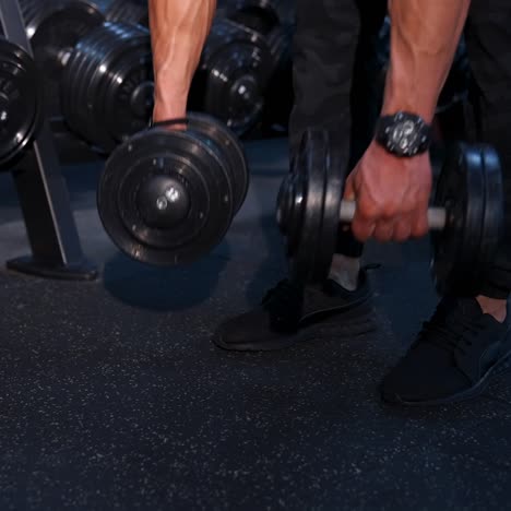 bodybuilder exercising with dumbbell at gym