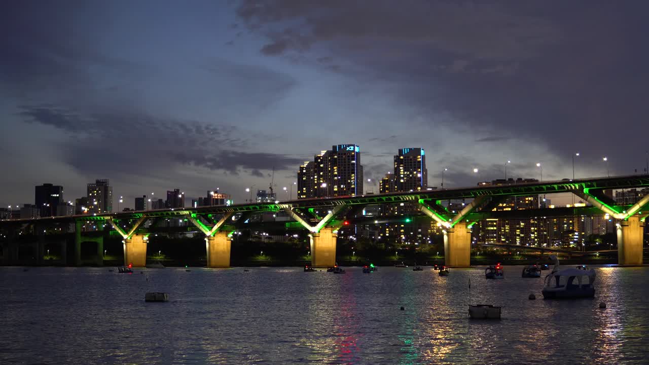 Cheongdam Bridge Over Han River With People Riding Duck Boats At Night In Seoul, South Korea. - wide shot