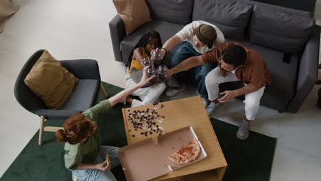 friends enjoying a puzzle, pizza, and drinks in a living room