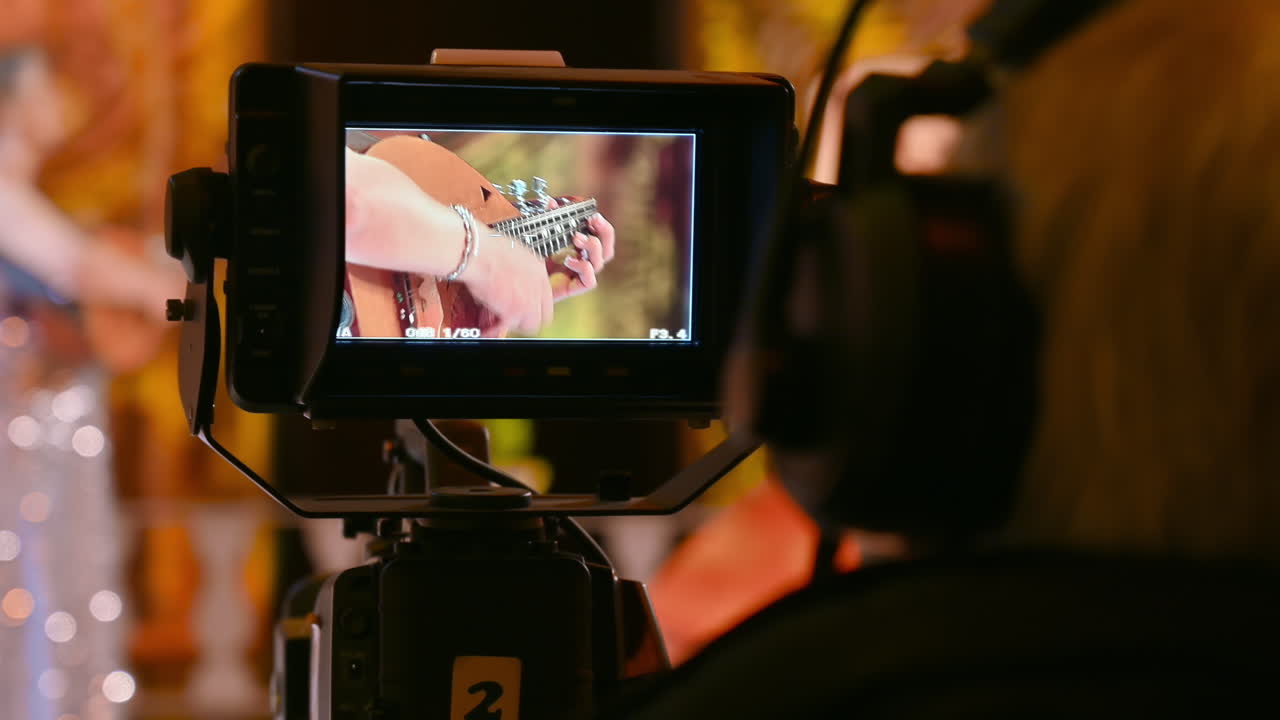 Man filming with professional camera on the backstage of a TV set