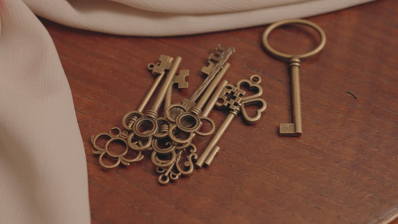 Close up of antique brass keys resting on polished wood surface