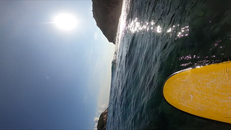 el sol brillante se refleja en el agua del océano mientras la persona navega, en cámara lenta pov vertical