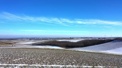 Drone-Volando-Sobre-Tierras-De-Cultivo-Nevadas-Cerca-De-La-Ciudad-De-Zistersdorf-En-Weinviertel,-Baja-Austria