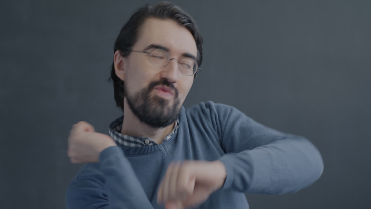 Man Dancing in front of a grey wall