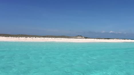 pov navegando hacia un banco de arena blanca en el agua turquesa del mar caribe, los roques
