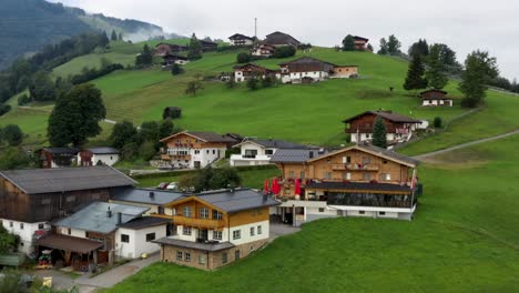 aerial footage of mountain town in austria witha colorful houses, green meadow