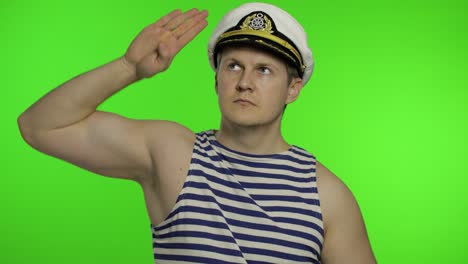 Young-sailor-man-salutes-with-hand,-looking-up.-Seaman-guy-in-sailor's-vests